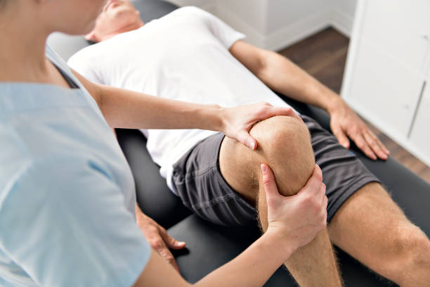 A Patient at the physiotherapy doing physical exercises with his therapist for recovery from pain. Recovery peptides have an anti-inflammatory funciton